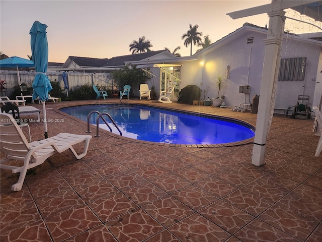 881 SW 137th Ct, Miami, FL 33184 - pool at dusk featuring a fenced in pool, fence, and a patio