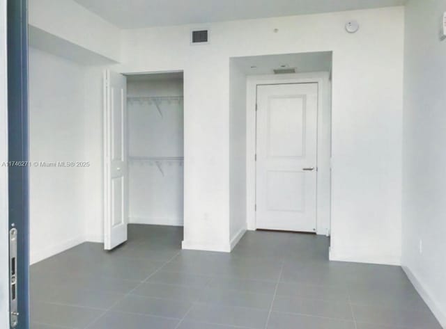 unfurnished bedroom featuring tile patterned flooring and a closet