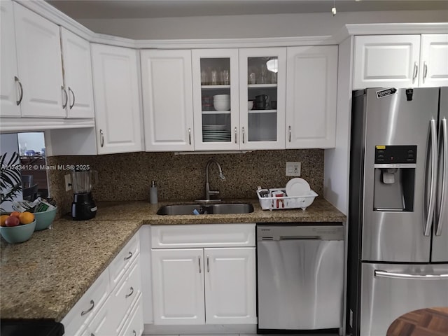 kitchen with white cabinets, tasteful backsplash, stainless steel appliances, and a sink