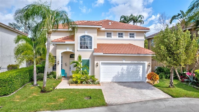 mediterranean / spanish home with a garage and a front lawn