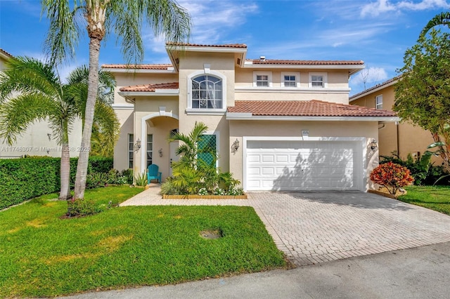 mediterranean / spanish home featuring a garage and a front lawn