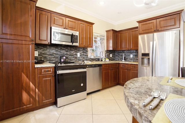 kitchen with tasteful backsplash, light tile patterned floors, stainless steel appliances, crown molding, and light stone countertops