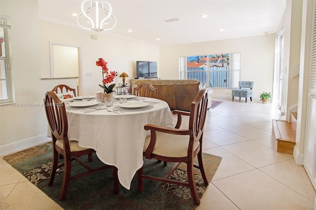 tiled dining area with ornamental molding and a chandelier