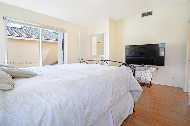 bedroom with vaulted ceiling and light wood-type flooring