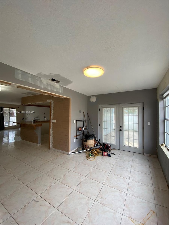 interior space featuring french doors and a textured ceiling