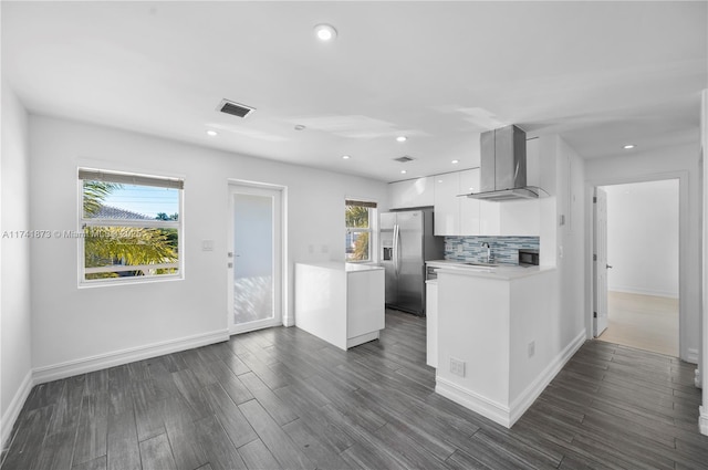 kitchen featuring dark wood-type flooring, backsplash, stainless steel refrigerator with ice dispenser, ventilation hood, and white cabinets