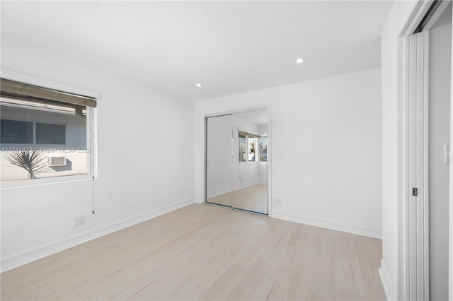 unfurnished bedroom with a closet and light hardwood / wood-style flooring