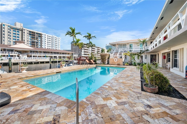 view of pool with a water view and a patio