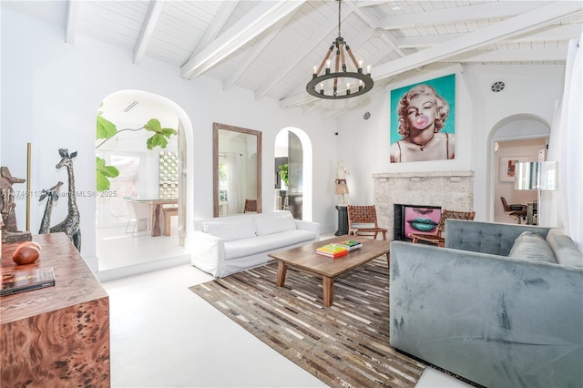 living area featuring arched walkways, a chandelier, a fireplace, high vaulted ceiling, and beam ceiling