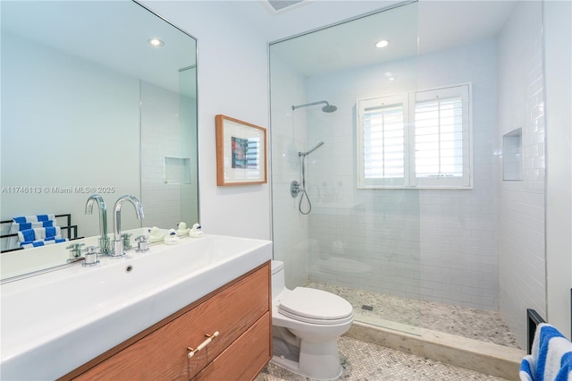 bathroom with recessed lighting, vanity, toilet, and a walk in shower