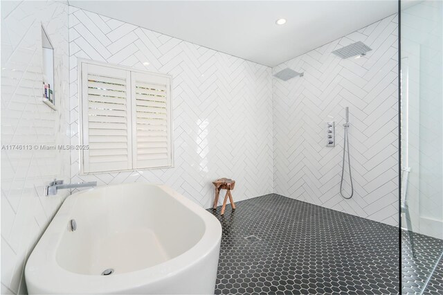 bathroom with a freestanding tub, tile walls, and a walk in shower