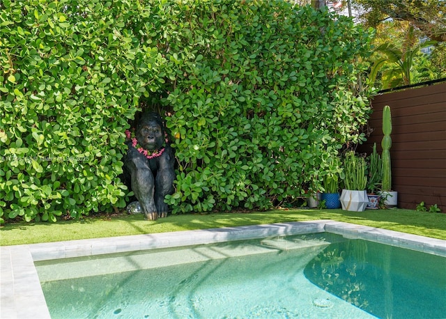 outdoor pool featuring a lawn and fence