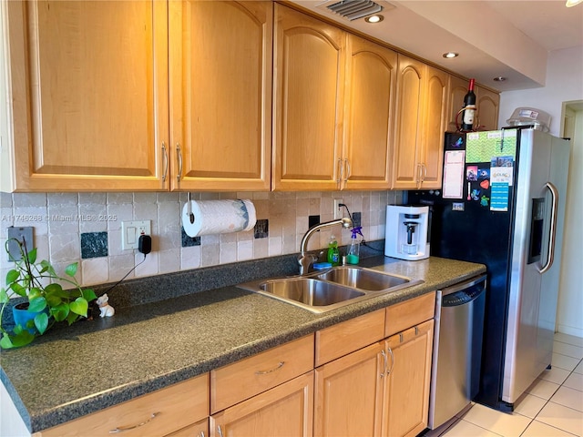 kitchen featuring sink, decorative backsplash, light tile patterned floors, and appliances with stainless steel finishes