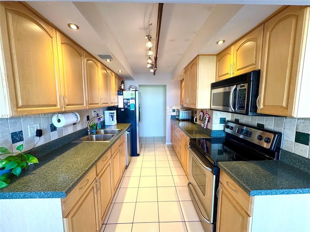 kitchen featuring sink, light tile patterned floors, appliances with stainless steel finishes, backsplash, and light brown cabinets