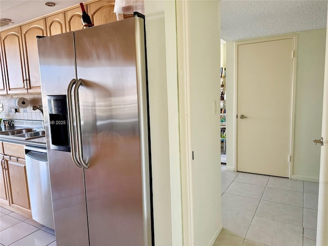 kitchen featuring sink, stainless steel appliances, a textured ceiling, light tile patterned flooring, and light brown cabinetry