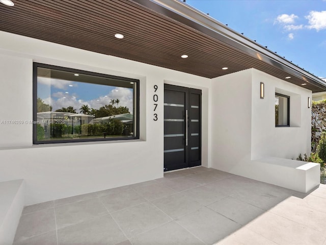 entrance to property featuring a patio and stucco siding