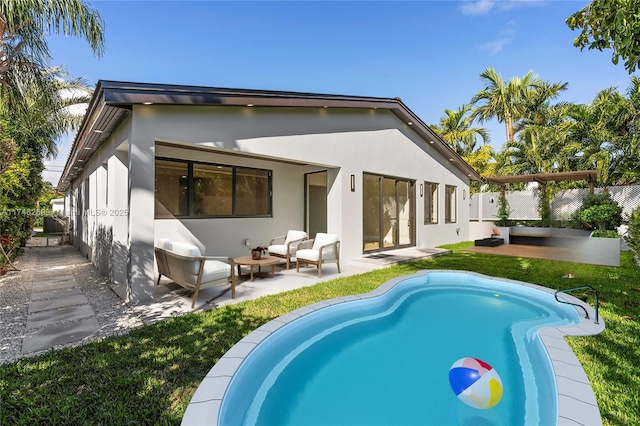 back of property featuring a fenced in pool, an outdoor hangout area, fence, a patio area, and stucco siding