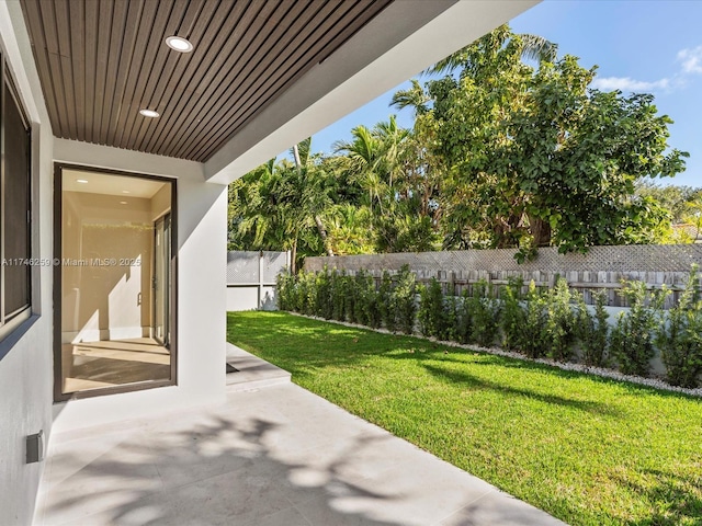 view of yard featuring fence and a patio