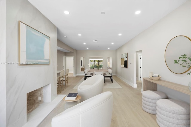 living area with recessed lighting, light wood-style flooring, and baseboards