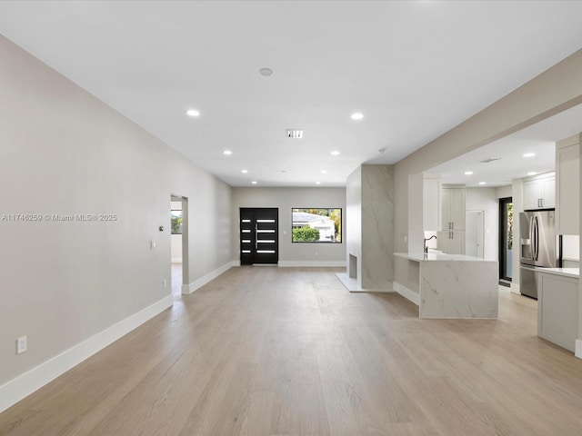 interior space with light wood-style floors, baseboards, and recessed lighting