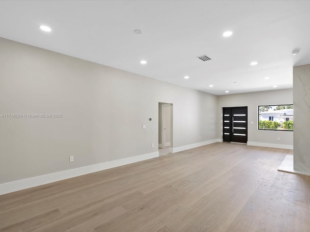 unfurnished room featuring light wood finished floors, visible vents, baseboards, and recessed lighting