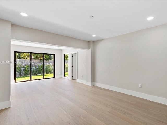 empty room with light wood-style floors, recessed lighting, and baseboards