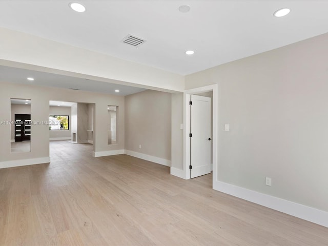 empty room with light wood-style flooring, recessed lighting, visible vents, and baseboards