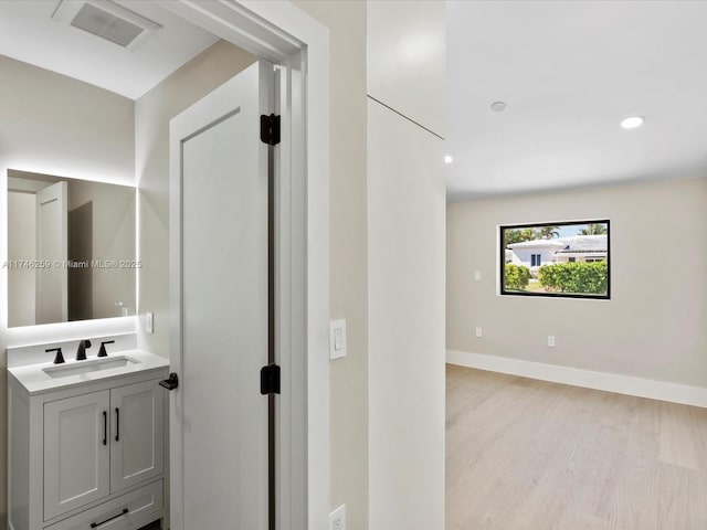 bathroom with recessed lighting, wood finished floors, vanity, visible vents, and baseboards