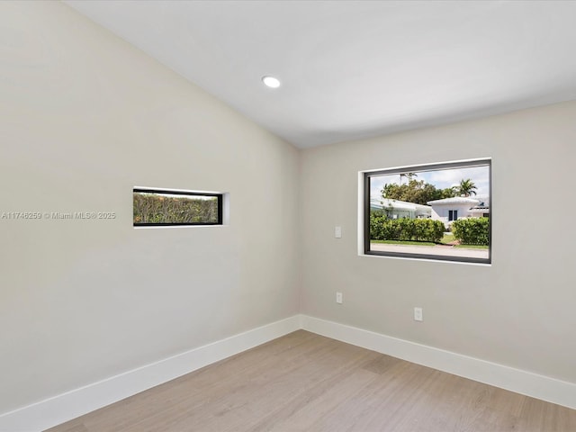 spare room featuring light wood-type flooring, baseboards, and recessed lighting