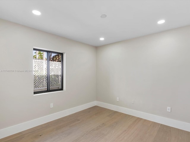 unfurnished room with light wood-style floors, baseboards, and recessed lighting