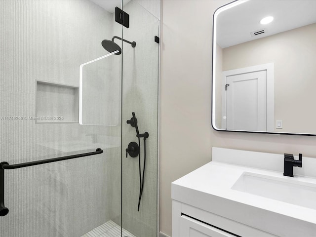 full bathroom with a stall shower, vanity, and visible vents