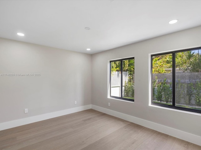 unfurnished room with recessed lighting, light wood-style flooring, and baseboards