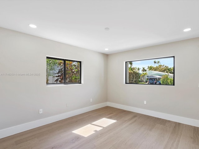 empty room with recessed lighting, baseboards, and wood finished floors