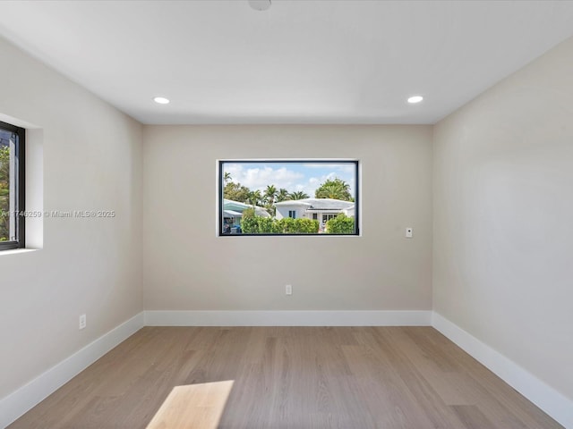 empty room featuring recessed lighting, wood finished floors, and baseboards