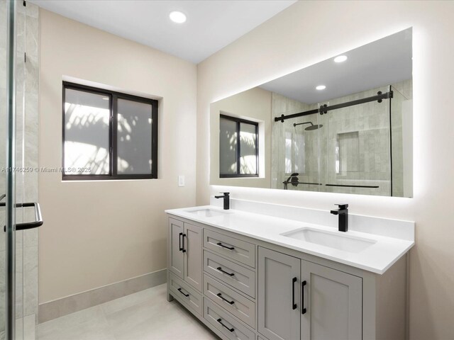 full bathroom with baseboards, double vanity, a sink, and a shower stall