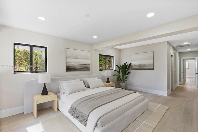 bedroom featuring light wood-type flooring, multiple windows, baseboards, and recessed lighting