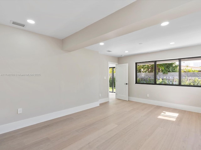 empty room with light wood-style flooring, baseboards, and recessed lighting