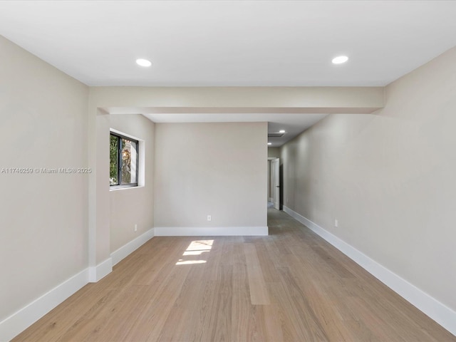 unfurnished room featuring light wood finished floors, baseboards, and recessed lighting