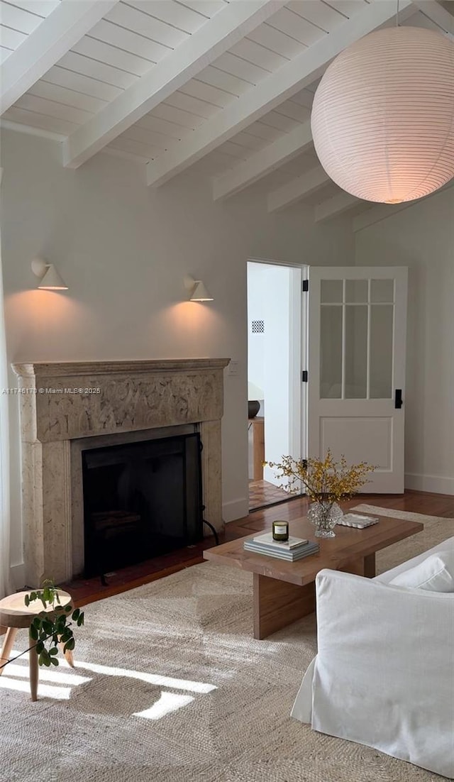 unfurnished living room with beamed ceiling, wood ceiling, a high end fireplace, and wood-type flooring