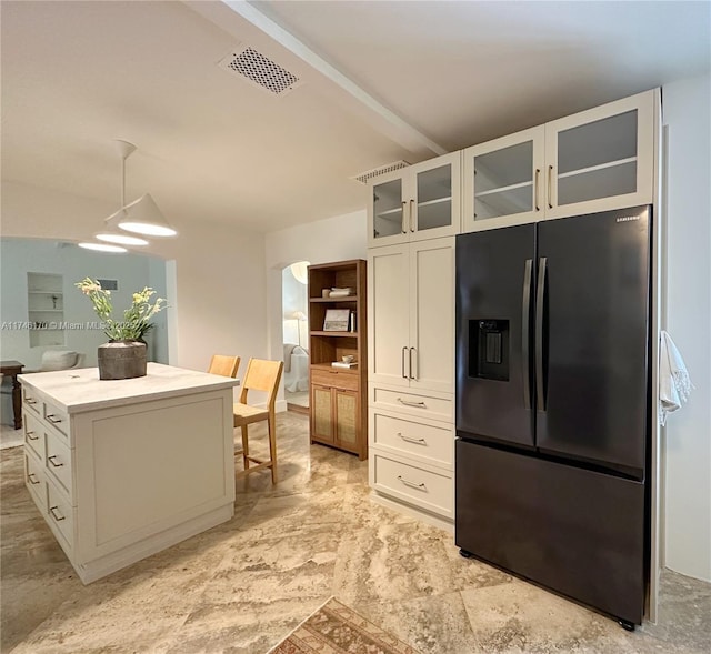 kitchen featuring pendant lighting, black fridge with ice dispenser, white cabinets, and a kitchen island