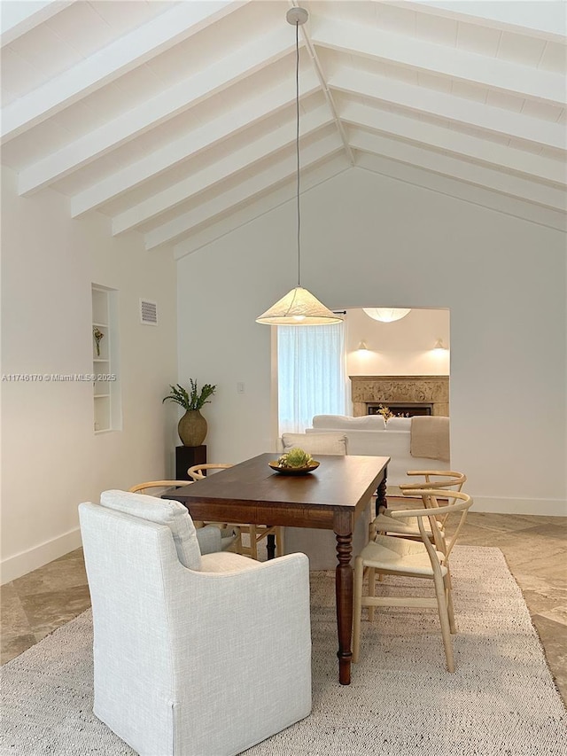 dining area featuring vaulted ceiling with beams