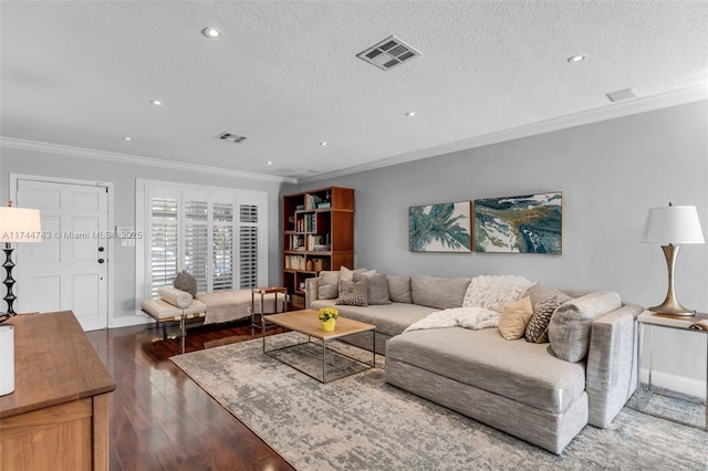 living room with baseboards, visible vents, dark wood-style floors, a textured ceiling, and crown molding