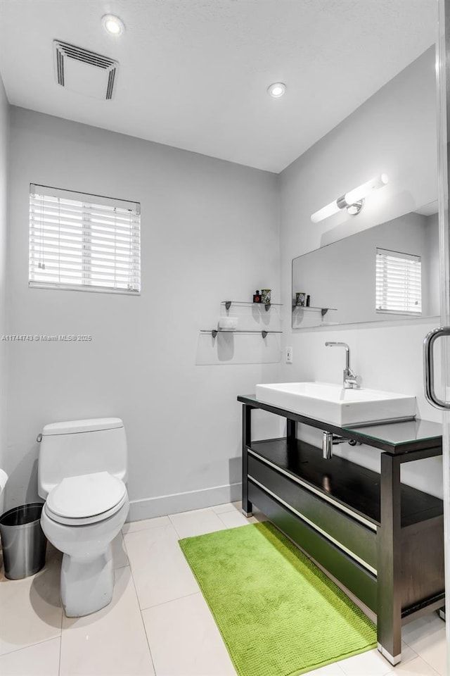 bathroom with toilet, visible vents, a wealth of natural light, and tile patterned floors