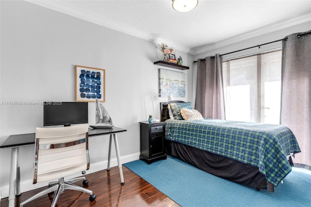 bedroom with baseboards, crown molding, and wood finished floors