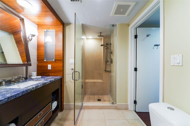 bathroom with tile patterned floors, vanity, toilet, and a shower with shower door