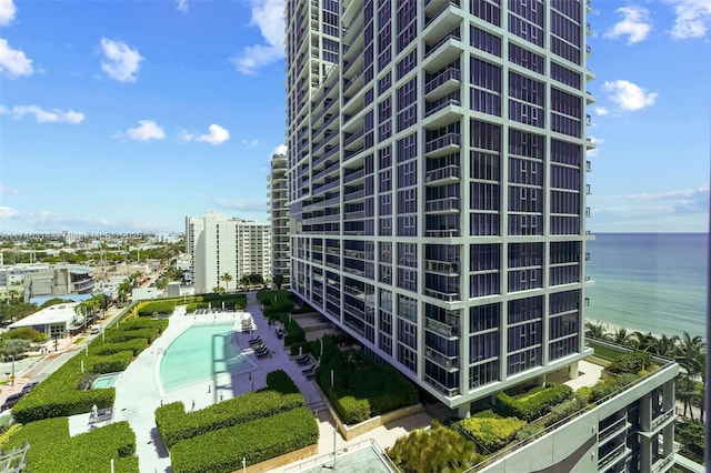 view of building exterior with a water view and a community pool