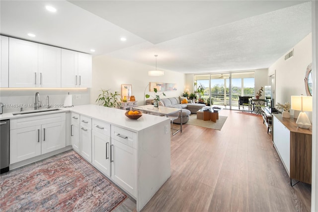 kitchen with a peninsula, visible vents, open floor plan, and a sink