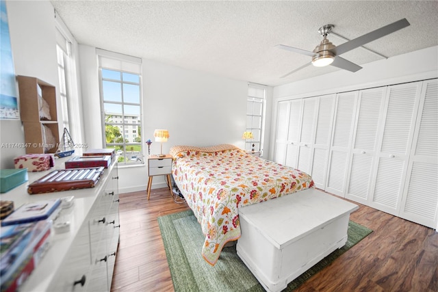 bedroom featuring a textured ceiling, a closet, wood finished floors, and a ceiling fan