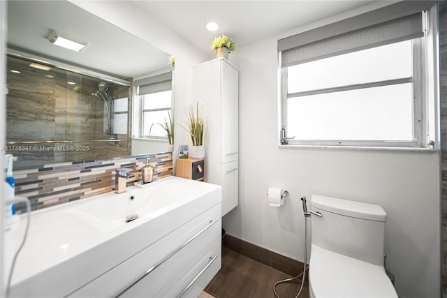 full bathroom with a stall shower, tasteful backsplash, toilet, wood finished floors, and vanity