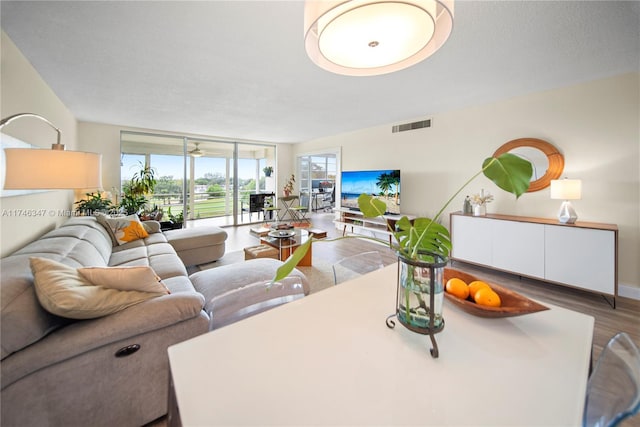 living room featuring a textured ceiling, visible vents, and wood finished floors